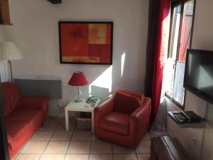 uma sala de estar com um sofá e uma cadeira e uma televisão em Gite a la campagne em Sardent