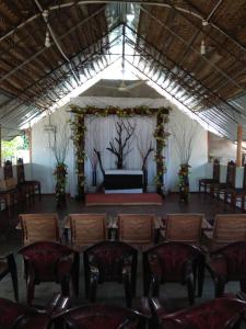 a room with a stage with chairs and a table at Beach Guest House Addalaichenai in Addalachenai