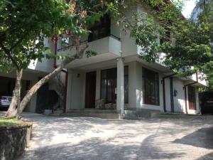 un bâtiment blanc avec des arbres devant lui dans l'établissement Avondale Colombo, à Maharagama