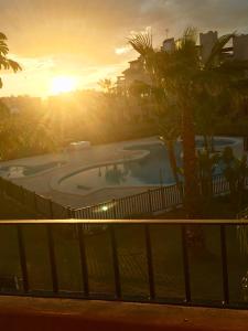 トレ・パチェコにあるResidencia del Corazonの夕日を背景にスイミングプールを望めます。