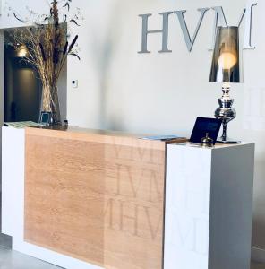 a reception desk with a lamp and a laptop on it at Hotel MedinaSalim in Medinaceli