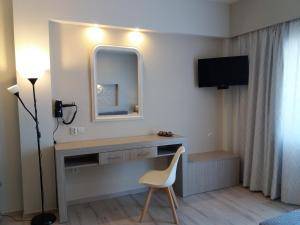 Zimmer mit einem Schreibtisch mit einem Spiegel und einem Stuhl in der Unterkunft Irida Studios in Ágios Dimítrios