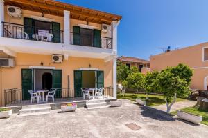 a villa with a balcony and a table and chairs at Nikos Apartments 1 in Kavos