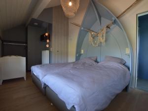 ウェームにあるEnchanting Holiday Home in Waimesのアーチ型のヘッドボード付きの客室の大型ベッド1台