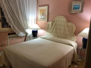 レトイアンニにあるLa Barca sul Mareのベッドルーム(白いベッド1台、ランプ2つ付)