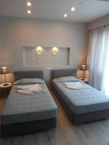 2 Einzelbetten in einem Zimmer mit 2 Lampen in der Unterkunft Irida Studios in Ágios Dimítrios
