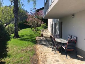 een terras met een tafel en stoelen in een tuin bij Katarina in Bled