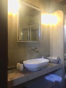 een badkamer met een grote witte wastafel en een spiegel bij Elia House in Megála Khoráfia