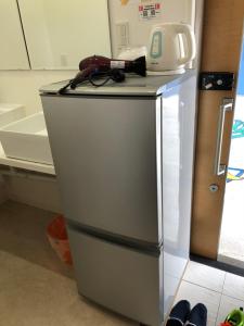 a small refrigerator with a phone on top of it at Guesthouse Geragera in Kobe