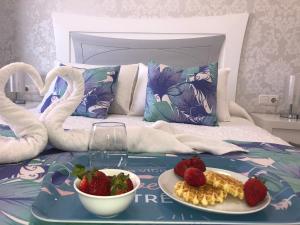 a tray with a plate of food on a bed at Apart. Playa La Barca in Costa Calma