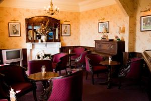 a restaurant with tables and chairs and a fireplace at Aran View Country House in Doolin