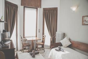 Habitación de hotel con cama, mesa y sillas en Ristorante Residence Giardini, en Piode