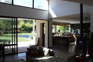 a living room with a couch and a table and a kitchen at La Villa Blanche in Bussy-Saint-Martin