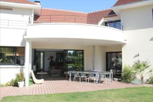 un patio con mesas y sillas en una casa en La Villa Blanche, en Bussy-Saint-Martin