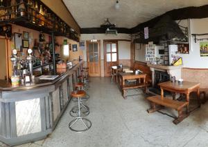 a bar in a restaurant with wooden tables and chairs at Hostal Santa Maria Do Poio in Padornelo