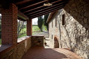 - un bâtiment en pierre avec un mur en briques et une arche dans l'établissement Antico Casale di Ferdinandi, à Bibbiena