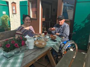 Ein Mann und eine Frau sitzen am Tisch und essen Essen. in der Unterkunft Concordia Apartments in Bad Wiessee