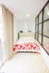 セビリアにあるpiso plaza del duqueのベッドルーム1室(赤い花のベッド1台付)