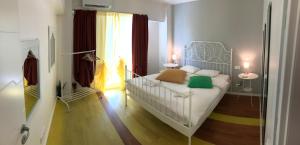 1 dormitorio con cama blanca y almohadas verdes en Green Apartment 6, en Bucarest