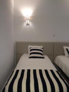 a bed with a black and white striped pillow at Nas Palhas Deitado in Fátima