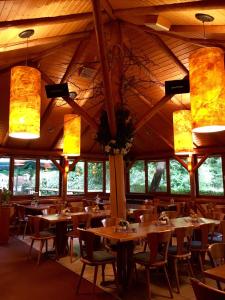 a dining room with tables and chairs and lights at Schlößlesmühle in Leinfelden-Echterdingen