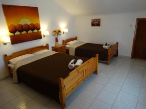a hotel room with two beds and a bathroom at Christakos Apartments in Nea Vrasna