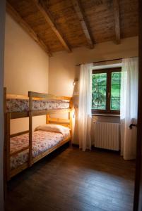 a bedroom with two bunk beds and a window at Agriturismo La Zangola in Tremosine Sul Garda