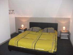 PlouézocʼhにあるGite de Kerfenefasのベッドルーム1室(黄色のベッド1台、ナイトスタンド2台付)