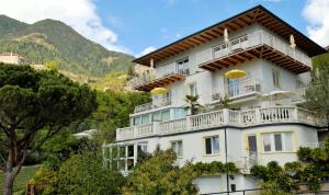 ein großes weißes Gebäude mit Balkonen und Bäumen in der Unterkunft Appartement Trafoier in Dorf Tirol