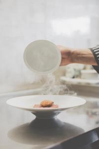 una persona sosteniendo un plato con una galleta en él en Ristorante Residence Giardini, en Piode