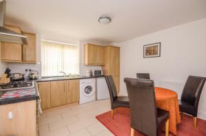a kitchen with a table and chairs in a room at Cosy Llandudno Apartments in Llandudno