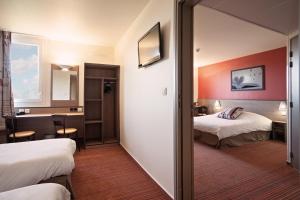a hotel room with two beds and a mirror at Ace Hotel Poitiers in Poitiers +5 photos