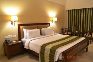 Ліжко або ліжка в номері Uday Suites - The Airport Hotel