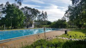 - une grande piscine dans une cour arborée dans l'établissement Lake House Benalla, à Benalla