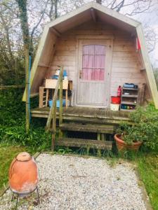 a small house with a porch and a door at Littlebridge Farmhouse in Bude