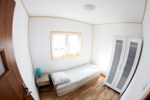 a small bedroom with a bed and a window at Rodzinna Kraina in Ustka