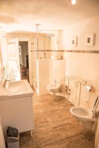 a white bathroom with two sinks and a toilet at LANDHAUS Mayer - TOP-Ferienwohnungen in Fischen