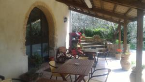 un patio con mesa de madera y sillas en un edificio en Borgo Montauto en San Gimignano