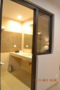 a bathroom with a sink and a mirror at Uday Suites - The Airport Hotel in Trivandrum