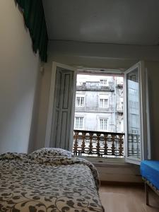 a bedroom with a bed and a large window at International Hostel Lapplandia B&B. in Vigo