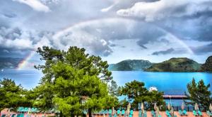 a rainbow over a body of water with trees at Marmaris Park Hotel in Marmaris