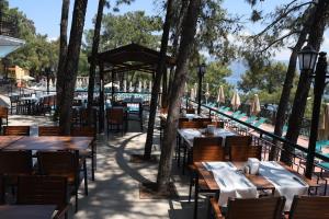 an outdoor restaurant with tables and chairs and trees at Marmaris Park Hotel in Marmaris