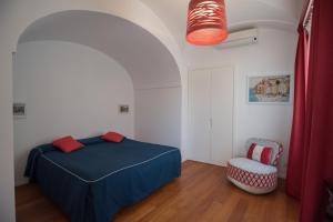 a bedroom with a blue bed and a chair at Villa Theile in Positano +7 photos
