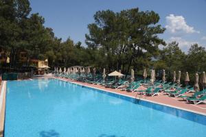 a swimming pool with lounge chairs and umbrellas at Marmaris Park Hotel in Marmaris