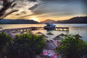 a boat is docked at a dock with umbrellas at Marmaris Park Hotel in Marmaris +37 photos