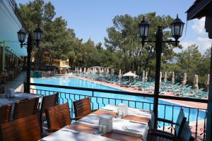 a restaurant with tables and chairs next to a swimming pool at Marmaris Park Hotel in Marmaris