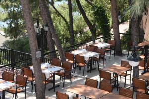 a row of tables and chairs on a balcony with trees at Marmaris Park Hotel in Marmaris