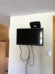 a flat screen tv hanging on a wall at 1 Lochness Rooms&Hostel in Drumnadrochit