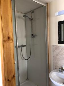 a shower with a glass door next to a sink at 1 Lochness Rooms&Hostel in Drumnadrochit