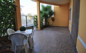 un patio con tavolo e sedie sul balcone. di La Baia Apartments by My Home Apulia a Torre Lapillo